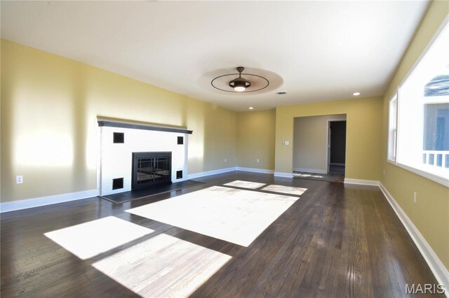 305 E Hauser St, Litchfield, IL 62056 - unfurnished living room with wood finished floors, a glass covered fireplace, and baseboards