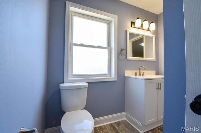 305 E Hauser St, Litchfield, IL 62056 - bathroom featuring wood finish floors, baseboards, vanity, and toilet
