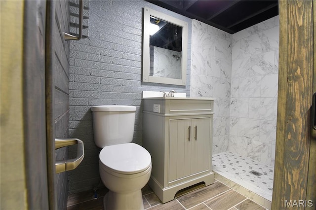 305 E Hauser St, Litchfield, IL 62056 - bathroom featuring toilet, tiled shower, vanity, and wood finished floors