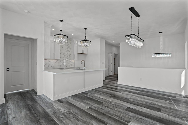 kitchen with a chandelier, a sink, light countertops, baseboards, and recessed lighting