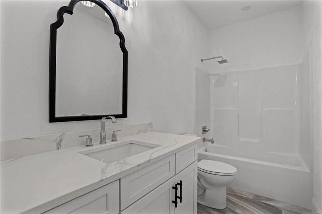 bathroom featuring toilet, vanity, and washtub / shower combination