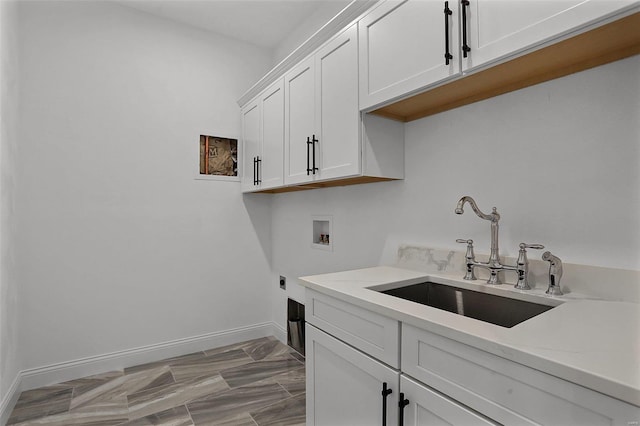 clothes washing area with hookup for an electric dryer, cabinet space, washer hookup, and baseboards