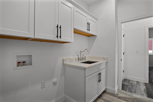 laundry room featuring hookup for a washing machine, cabinet space, and baseboards