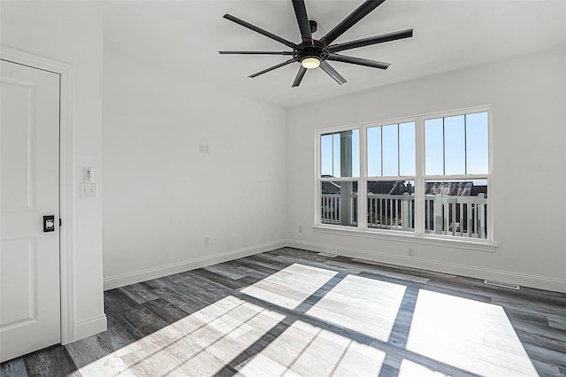 empty room with wood finished floors, baseboards, and a ceiling fan
