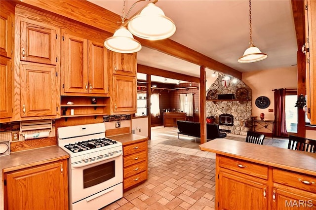 26 Gap Rd, Tunas, MO 65764 - kitchen featuring white range with gas cooktop, open floor plan, brick patterned floors, beamed ceiling, and a stone fireplace