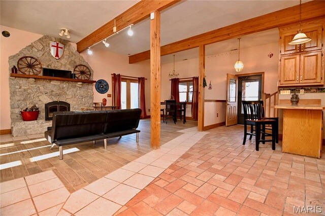 26 Gap Rd, Tunas, MO 65764 - living area with beamed ceiling, baseboards, track lighting, and a stone fireplace