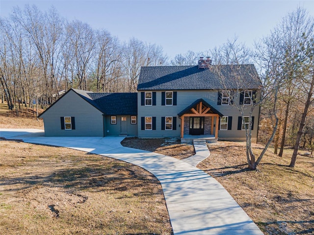 view of front of house featuring a chimney, a porch, and roof with shingles