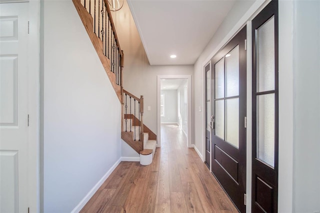 foyer entrance featuring stairs, baseboards, light wood-style floors, and recessed lighting