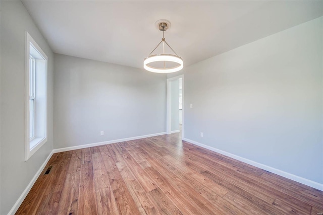 spare room with wood finished floors and baseboards