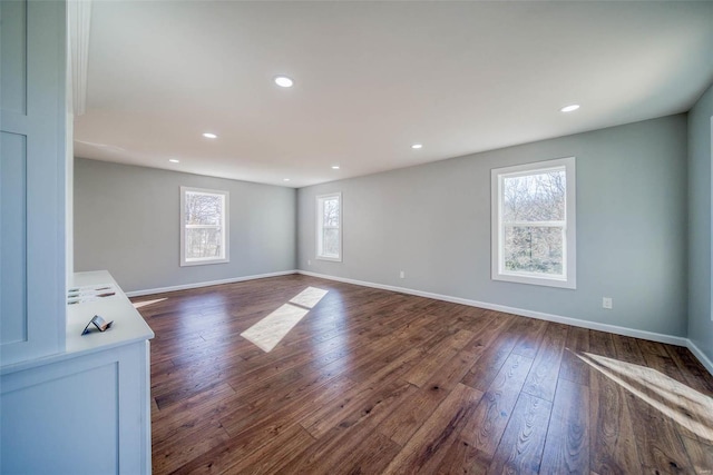 unfurnished living room with dark wood finished floors, baseboards, and recessed lighting