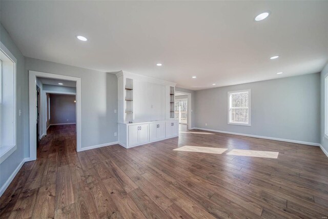 unfurnished living room featuring dark wood finished floors, baseboards, and recessed lighting