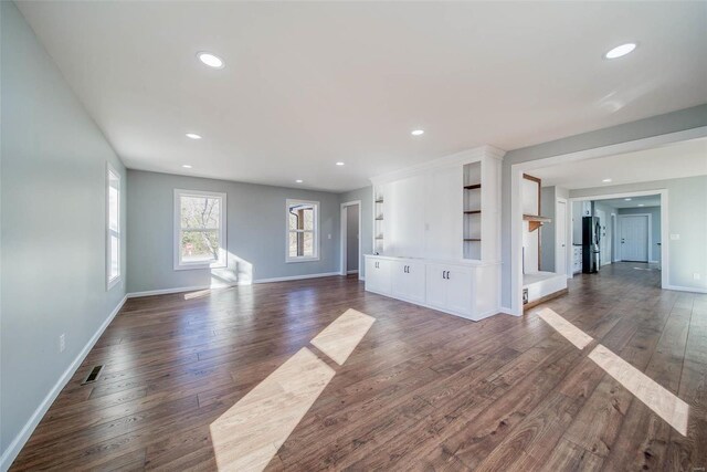 unfurnished living room featuring dark wood finished floors, recessed lighting, and baseboards