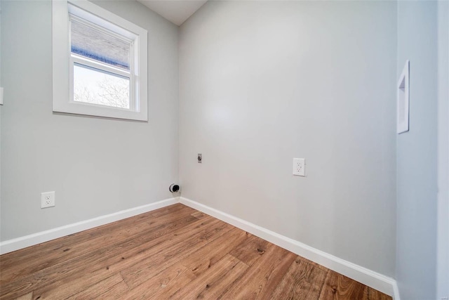 laundry room featuring hookup for an electric dryer, baseboards, and wood finished floors