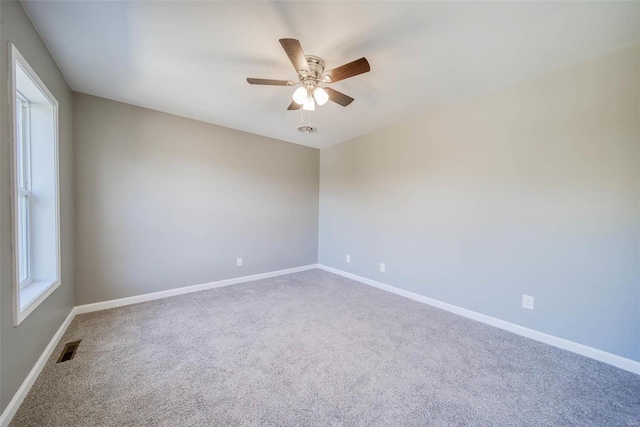 carpeted empty room with ceiling fan and baseboards