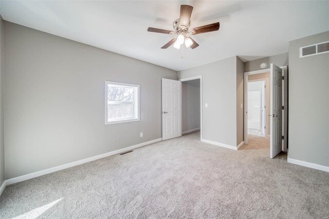 unfurnished bedroom with light colored carpet, baseboards, and a ceiling fan