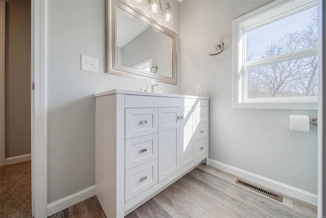 bathroom featuring baseboards, vanity, and wood finished floors