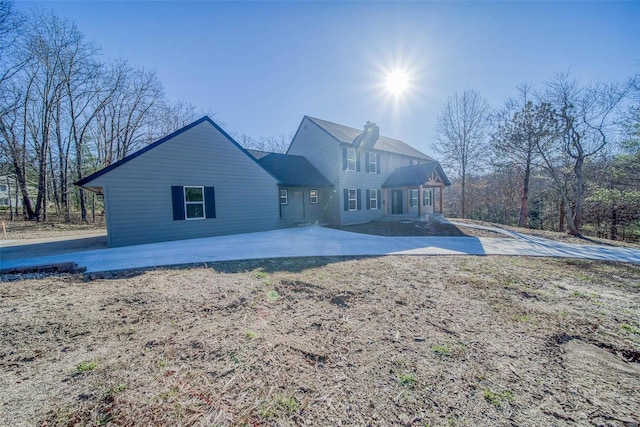 rear view of property featuring a chimney