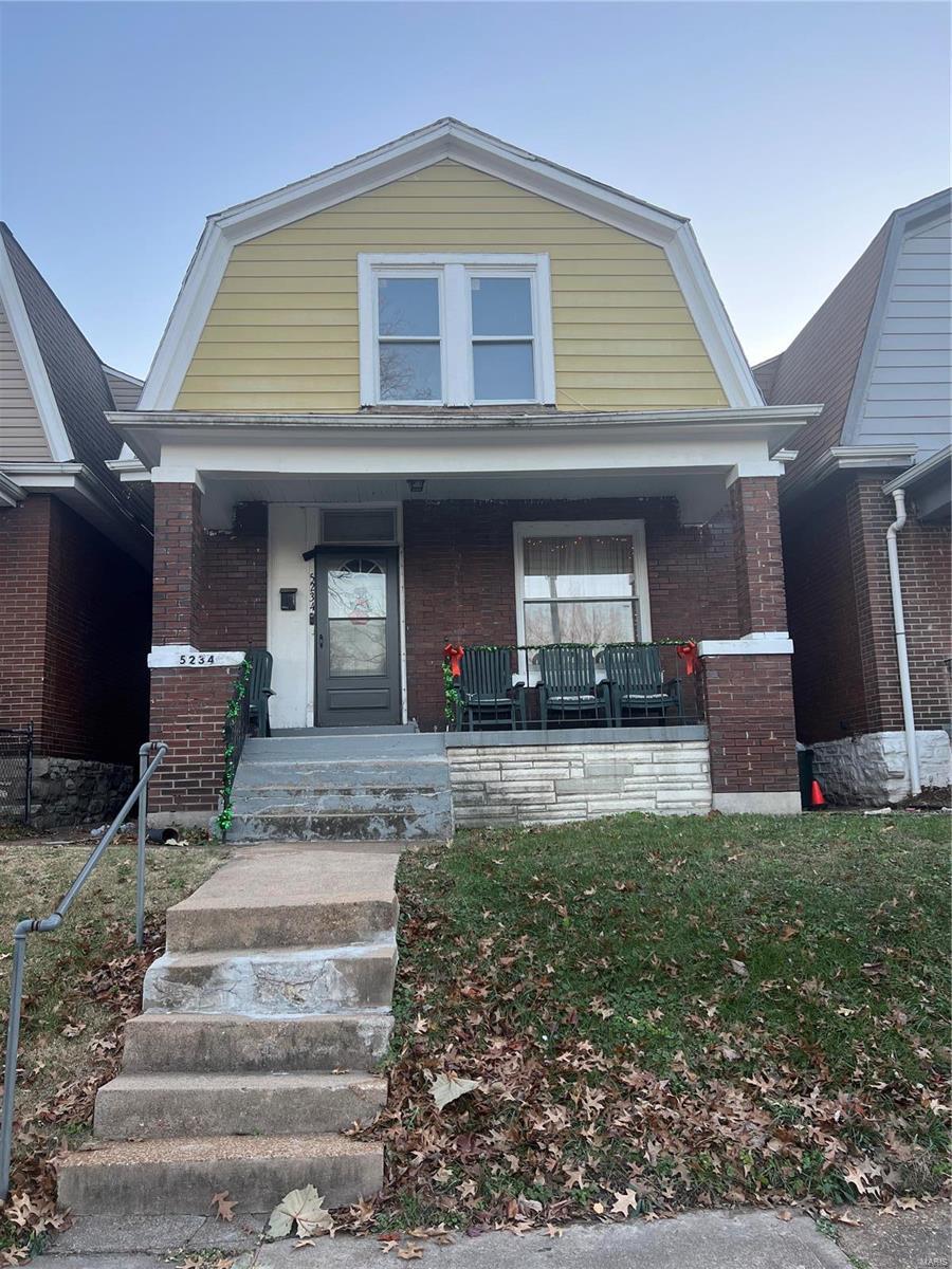5234 Terry Ave, Saint Louis, MO 63115 - dutch colonial featuring a gambrel roof, brick siding, and covered porch