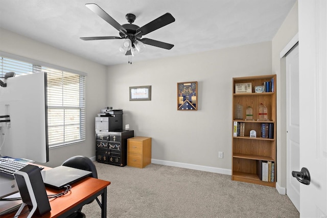 home office featuring carpet floors, a ceiling fan, and baseboards