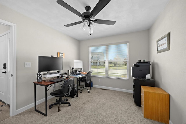carpeted office space with baseboards and ceiling fan