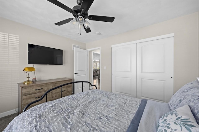 carpeted bedroom with a closet, baseboards, and ceiling fan
