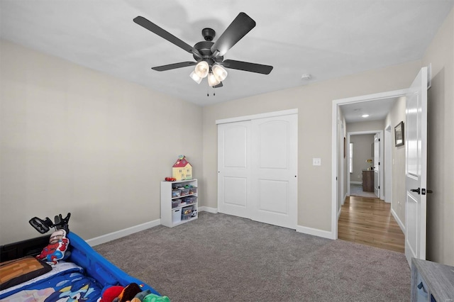 carpeted bedroom featuring baseboards, a closet, and a ceiling fan