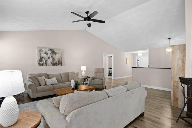 living room with wood finished floors, ceiling fan, baseboards, and lofted ceiling