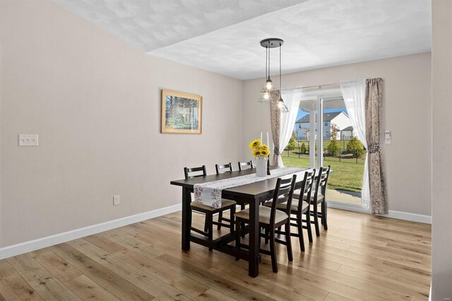 dining room with baseboards and light wood-style flooring