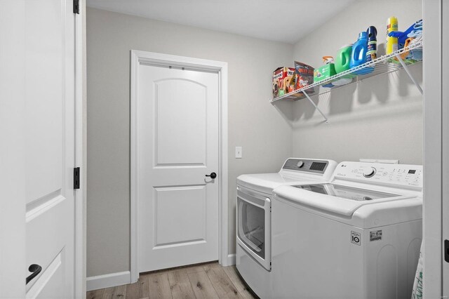 washroom featuring washing machine and clothes dryer and light wood-style flooring