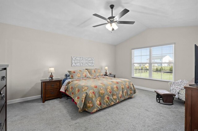 carpeted bedroom featuring baseboards, lofted ceiling, and a ceiling fan