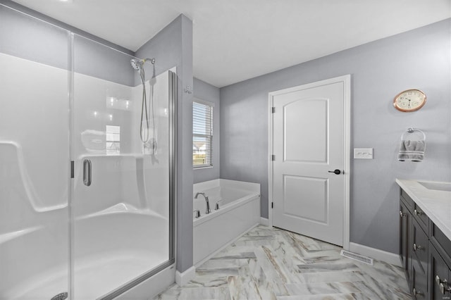 bathroom with a shower stall, a bath, vanity, and baseboards