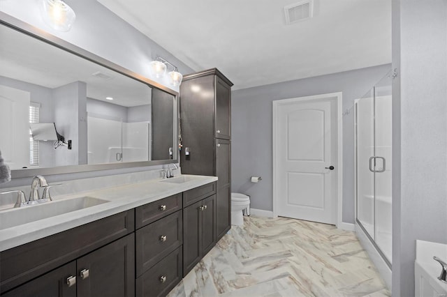 bathroom featuring a shower stall, toilet, double vanity, and baseboards