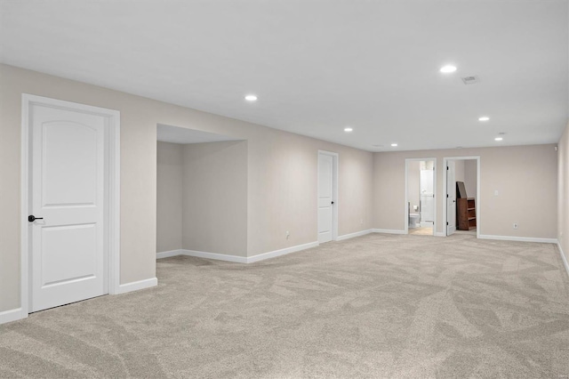 finished basement featuring light carpet, baseboards, and recessed lighting
