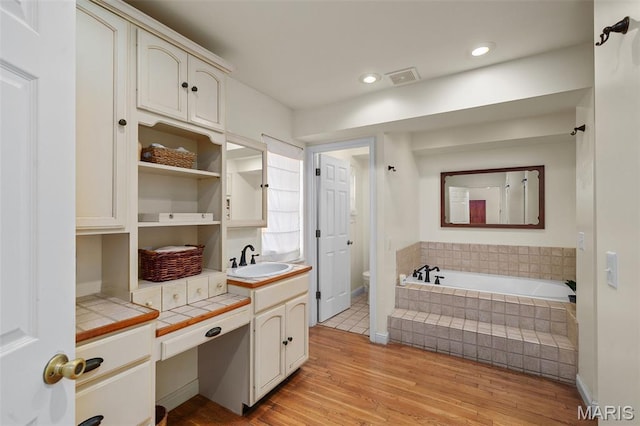 729 W Lockwood Ave, Saint Louis, MO 63122 - bathroom with wood finished floors, a bath, vanity, and recessed lighting