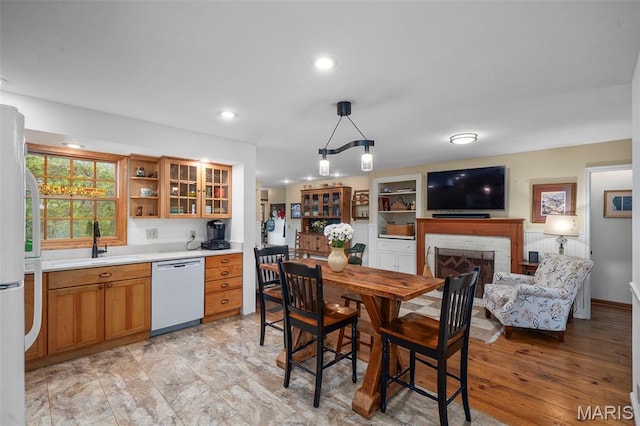 729 W Lockwood Ave, Saint Louis, MO 63122 - kitchen with white appliances, open shelves, light countertops, a brick fireplace, and hanging light fixtures