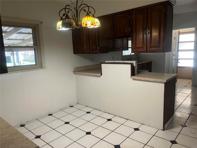 kitchen featuring healthy amount of natural light, dark brown cabinets, and light countertops