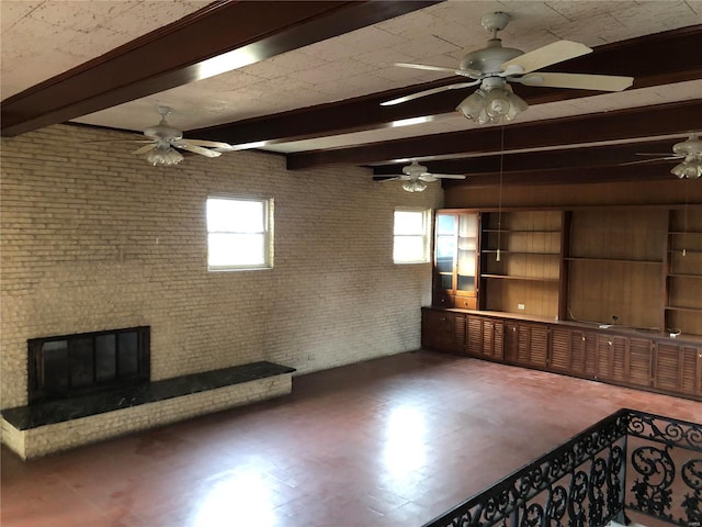 unfurnished living room featuring beam ceiling, ceiling fan, and a brick fireplace