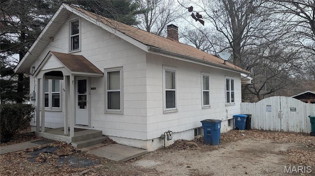 12532 Bellefontaine Rd, Saint Louis, MO 63138 - view of front of house with a chimney, roof with shingles, and fence