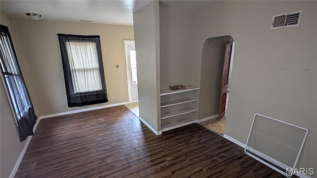 12532 Bellefontaine Rd, Saint Louis, MO 63138 - empty room featuring arched walkways, wood finished floors, and baseboards