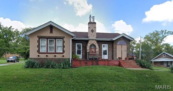 104 Emerling Dr, Saint Louis, MO 63121 - view of front of house with a front lawn and a chimney