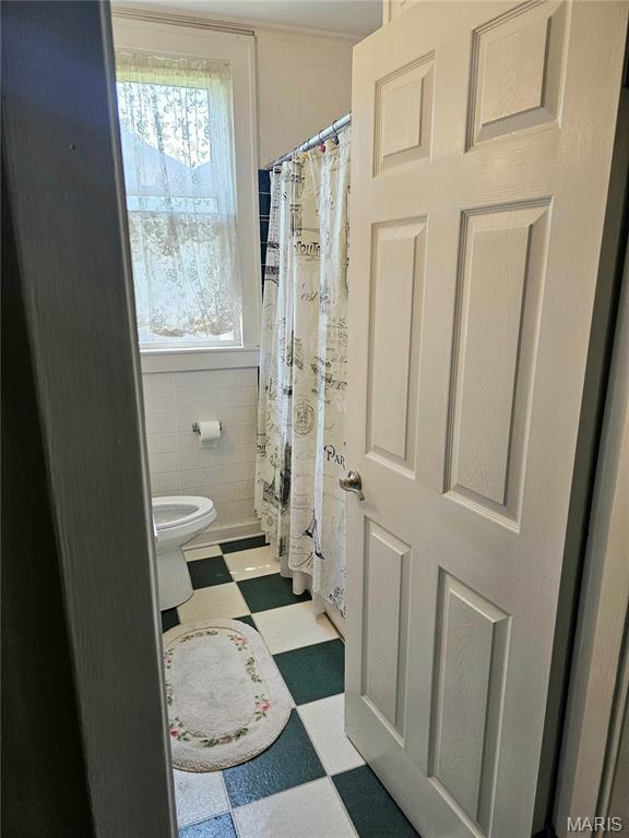 104 Emerling Dr, Saint Louis, MO 63121 - full bathroom featuring tile patterned floors, toilet, tile walls, and curtained shower