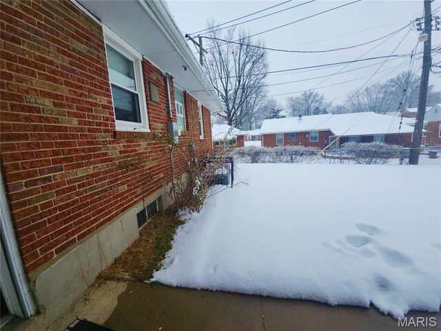 1110 Astoria Dr, Saint Louis, MO 63137 - snow covered property with brick siding