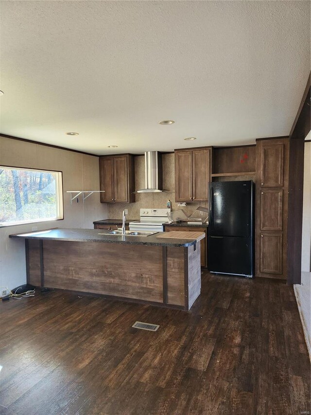 15005 Carthage Rd, Dixon, MO 65459 - kitchen featuring freestanding refrigerator, wall chimney exhaust hood, dark wood-type flooring, a sink, and a textured ceiling