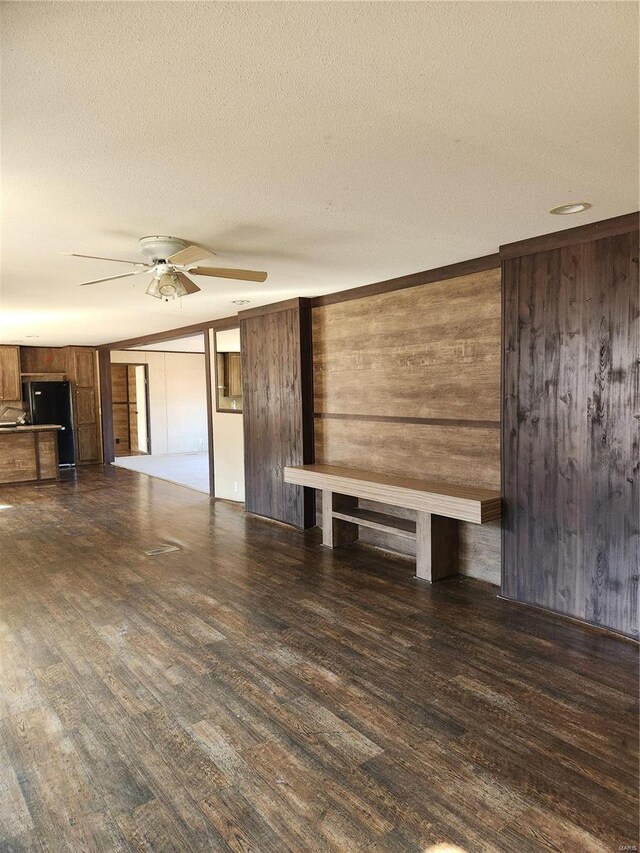 15005 Carthage Rd, Dixon, MO 65459 - unfurnished living room featuring wooden walls, a ceiling fan, wood finished floors, and a textured ceiling