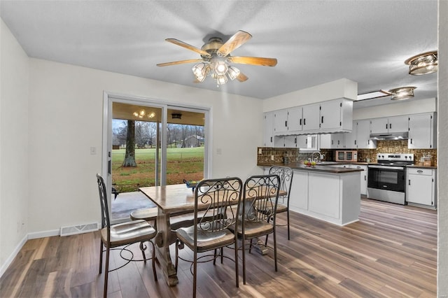 dining area with wood finished floors, ceiling fan, baseboards, and a textured ceiling