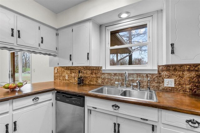 kitchen with dishwasher, a sink, dark countertops, white cabinets, and tasteful backsplash