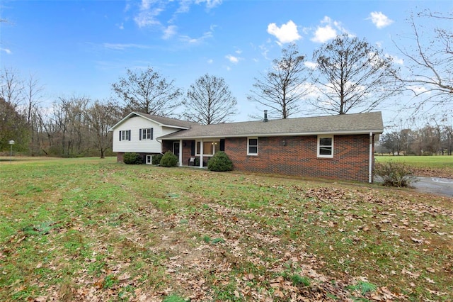tri-level home featuring brick siding and a front yard