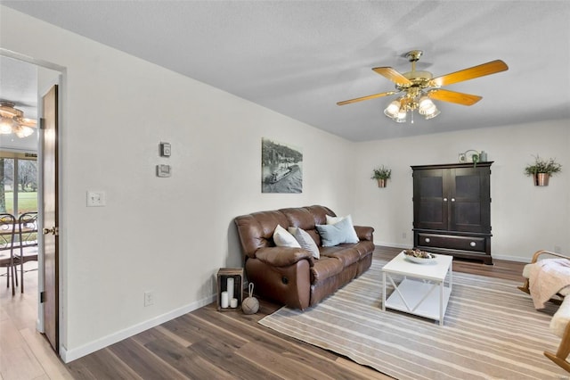 living room with ceiling fan, wood finished floors, and baseboards