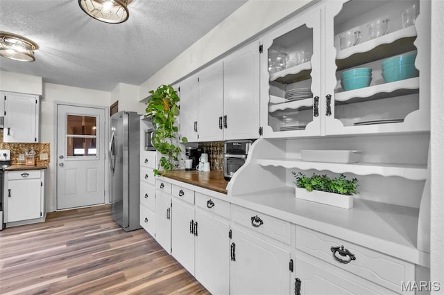 70 Garnet Ln, Cape Girardeau, MO 63701 - kitchen with a textured ceiling, wood finished floors, freestanding refrigerator, white cabinetry, and glass insert cabinets