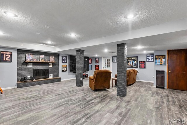 70 Garnet Ln, Cape Girardeau, MO 63701 - living area with a textured ceiling, ornate columns, a fireplace, baseboards, and wood finished floors